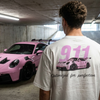 T-shirt Porsche 911 GT3 RS rose porté de dos dans un parking souterrain, face à une GT3 RS 992 rose