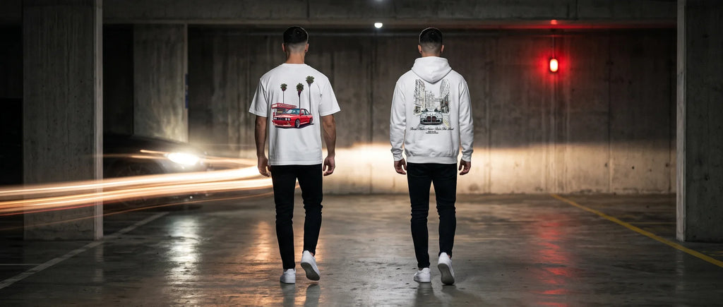 Deux mannequins de dos marchant dans un parking souterrain la nuit, traînées de phares au sol, en t-shirt BMW M3 E30 et sweat BMW M3 G80
