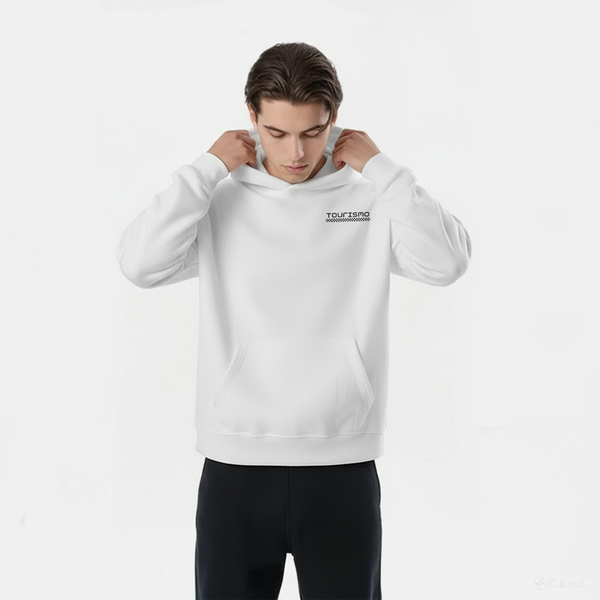Homme portant un hoodie blanc TOURISMO, enfilant la capuche, regard vers le bas, fond clair