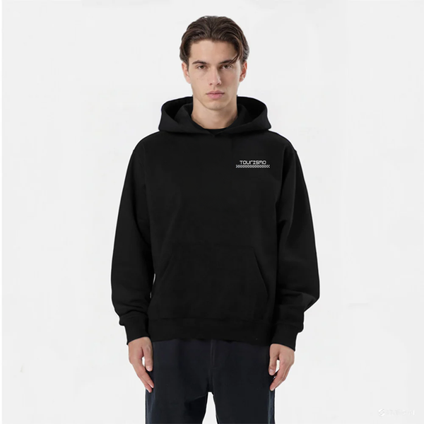 Homme en hoodie noir TOURISMO, pantalon foncé, fond blanc