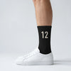 Calcetines Kimi Antonelli 12 negro, puestos, vista de perfil con zapatillas blancas