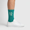 Calcetines Kimi Antonelli 12 turquesa, puestos, vista de perfil con zapatillas blancas