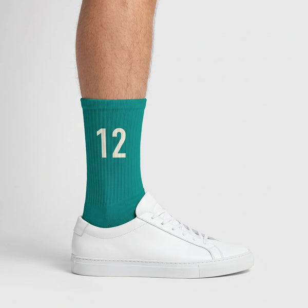 Calcetines Kimi Antonelli 12 turquesa, puestos, vista de perfil con zapatillas blancas