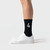 Calcetines Lando Norris 4 negro, puestos, vista de perfil con zapatillas blancas