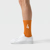 Calcetines Lando Norris 4 naranja, puestos, vista de perfil con zapatillas blancas