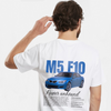 T-shirt blanc BMW M5 V10 avec voiture bleue dans le dos, porté par mannequin